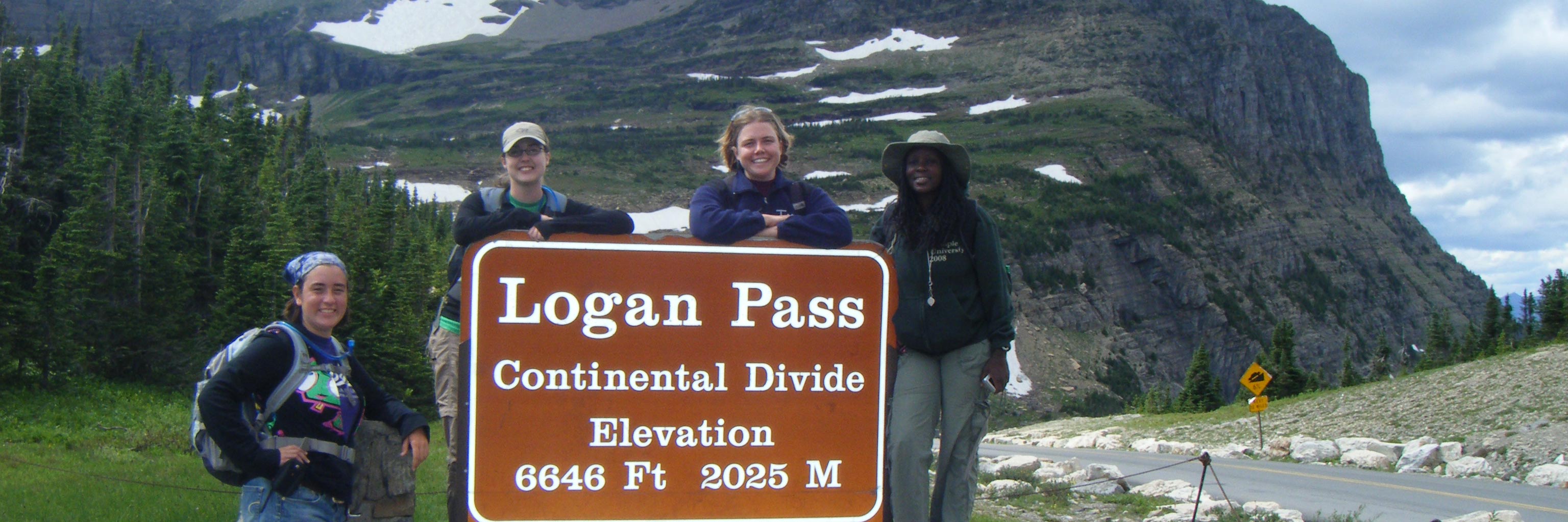 Students stand around a sign that says Logan's Pass